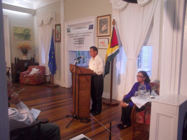 Mr Clarindo Lucas makes closing remarks at the launch. Ms Melinda Janki. Justice Institute Guyana in foreground.